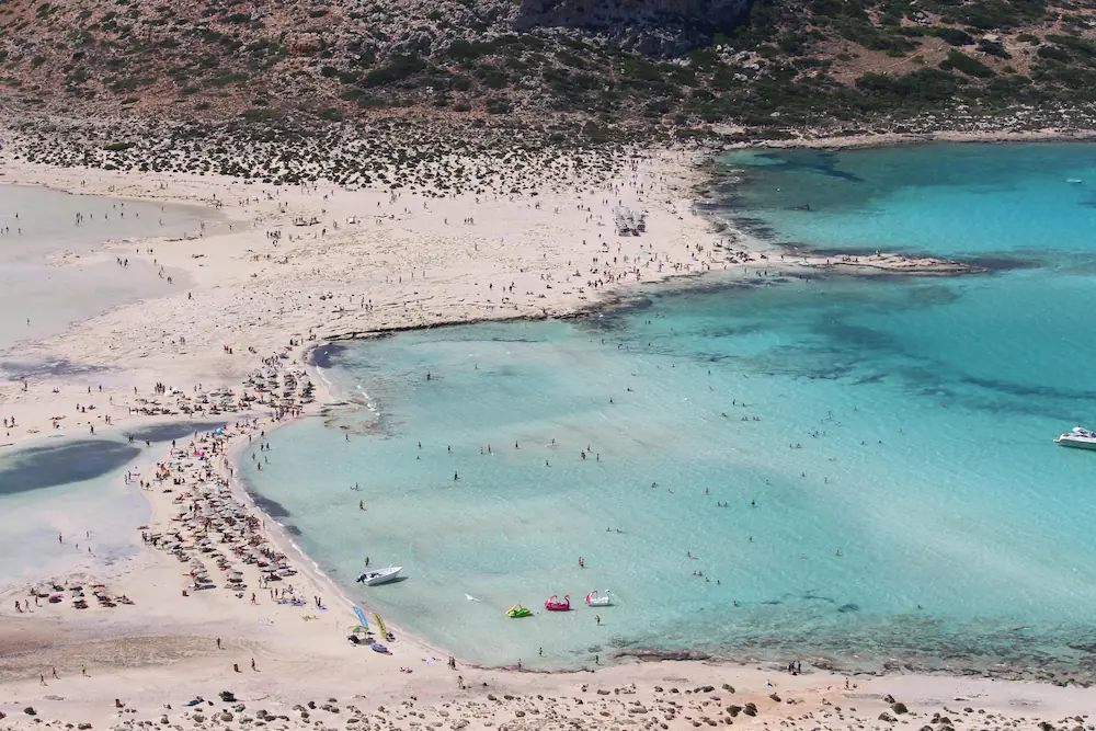 Isolated beach landscape in Crete, surrounded by imposing mountains and crystal-clear waters.