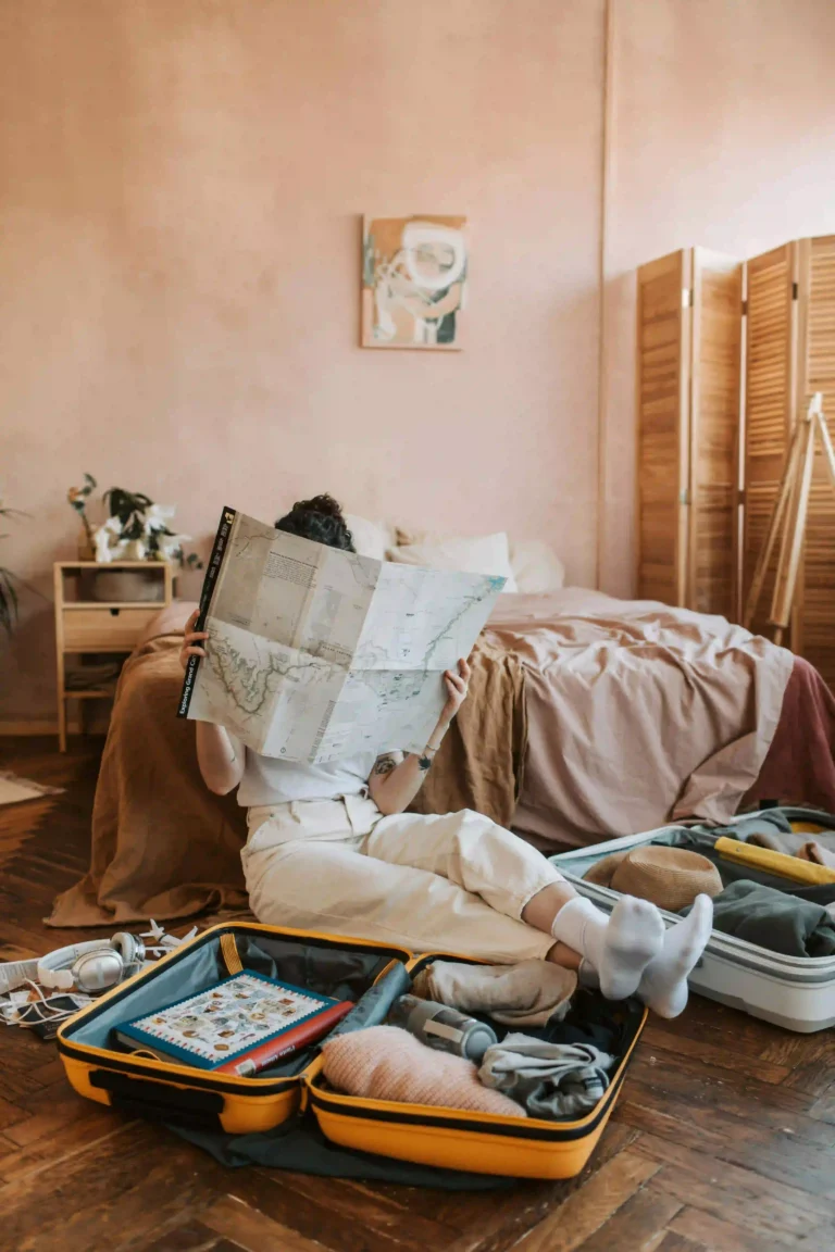 Woman preparing a literary trip, sitting in her room with open suitcases and a detailed map.